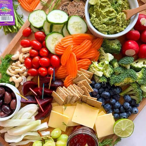 Fall veggie charcuterie board with baby carrots, carrot chips, carrot sticks and cilantro hummus.